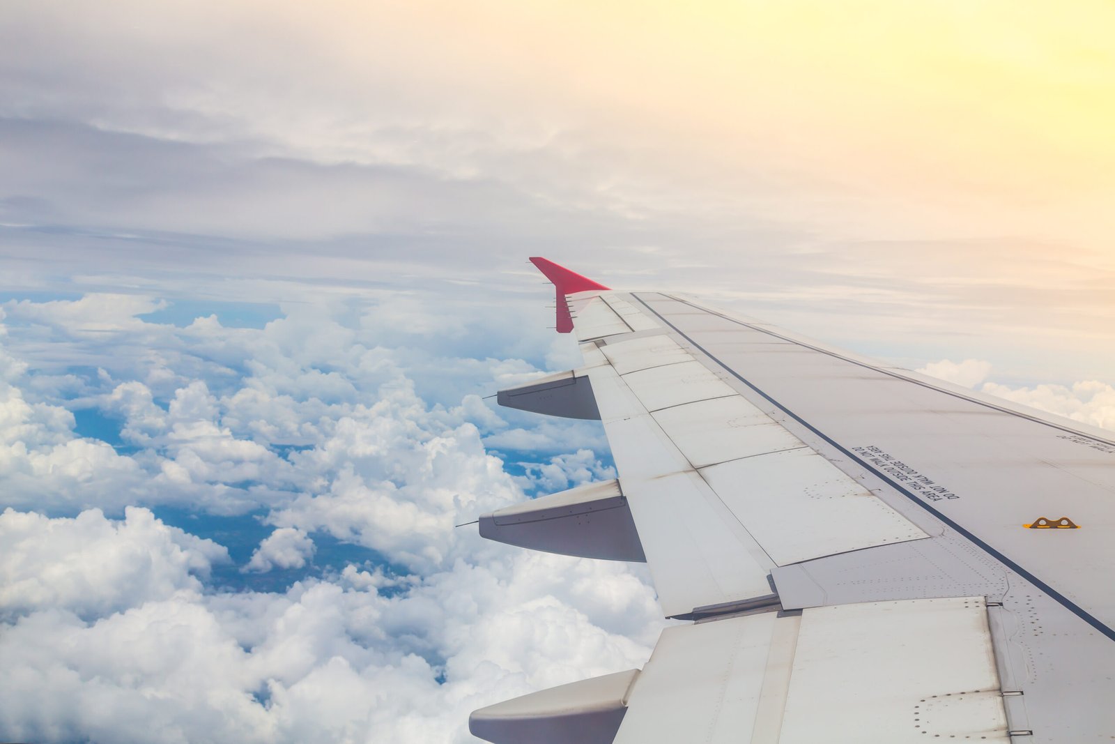 Wing of an airplane flying above the clouds